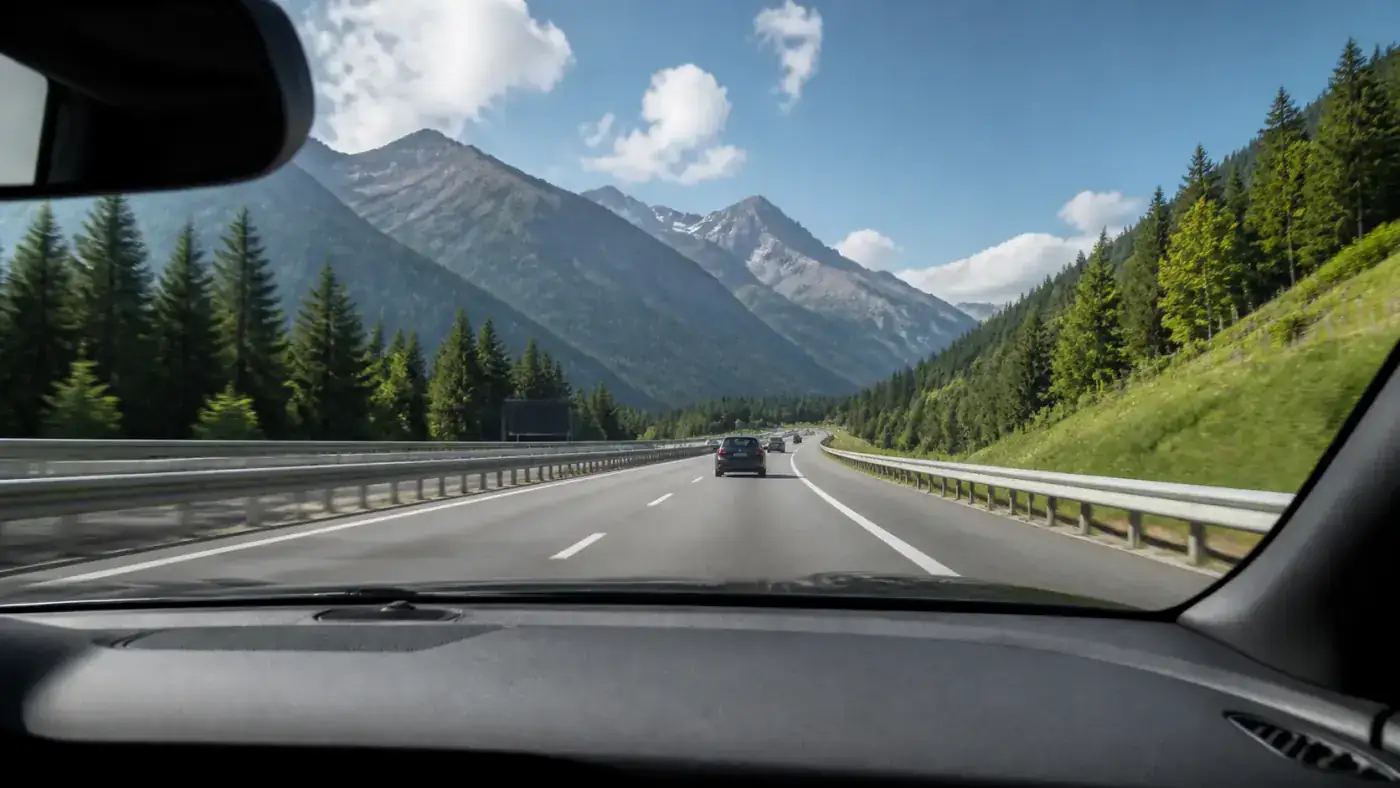 View through a clean car windscreen onto an alpine motorway, the glass where a vignette sticker used to be glued